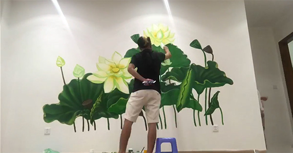 Họa sĩ đang vẽ họa tiết hoa sen cho quán tại Hưng Yên