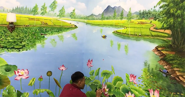 Họa sĩ đang vẽ tranh tường hoa sen cho nhà ở tại Hưng Yên